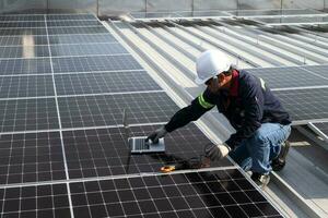 technicien inspecter solaire panneaux sur usine toit vérifier et maintenir le solaire panneau toit une équipe de techniciens installation solaire panneaux sur le toit de une gratte-ciel bâtiment photo