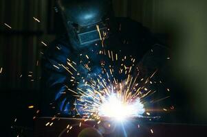 industriel ouvriers à acier structure soudage plante une soudeur est soudage métal les pièces dans une petit atelier. photo
