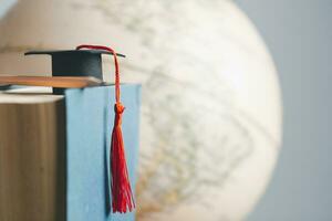 l'obtention du diplôme casquette avec Terre globe. concept de global affaires étude, à l'étranger éducatif, retour à école. éducation dans global monde, étude à l'étranger affaires dans les universités dans mondial. Langue étude photo