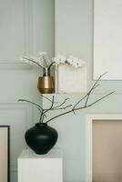 élégant minimaliste scandinave vivant pièce décor dans gris. branches de printemps des arbres dans des vases dans le pièce photo