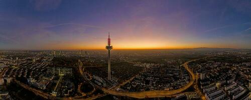 image panoramique par drone de la ligne d'horizon de francfort avec tour de télévision le soir lors d'un coucher de soleil coloré et impressionnant photo