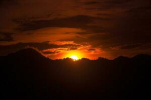 Montagne de pointe silhouette contre le coucher du soleil photo