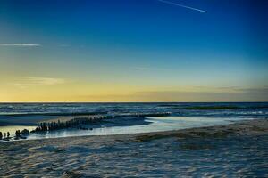 Orange le coucher du soleil sur le plage de le baltique mer dans Pologne photo