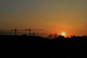 pittoresque, coucher de soleil, soleil, nuage, ciel ville avec construction grues, photo