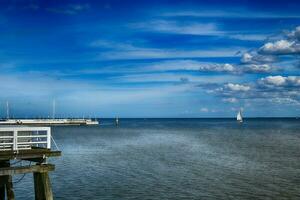 bleu paysage avec le mer et une blanc voilier sur le horizon sur le palet baie dans Pologne photo