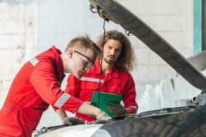 technicien équipe vérification moderne voiture à garage, Jeune caucasien voiture mécanicien avec une liste de contrôle, mécanique dans uniforme sont travail dans auto service, voiture réparation et entretien photo