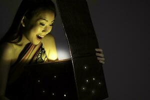 asiatique femme ouverture mystique livre boîte magique lumière foncé Contexte photo