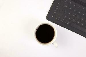 noir ordinateur clavier café tasse stylo sur blanc Contexte Haut vue copie texte espace photo