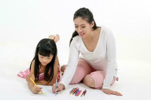 Sud est asiatique mère fille enfant étude lis écrire parler sur sol blanc Contexte crayon papier photo