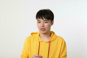 Jeune bien à la recherche asiatique chinois malais homme pose visage corps expression mode émotion sur blanc Contexte sous le choc surpris photo