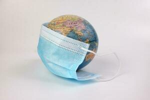 globe planète monde carte Terre portant visage masque sur blanc Contexte photo