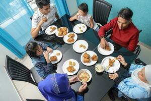 groupe de sud-est asiatique adulte enfant fille Masculin femelle en mangeant le déjeuner à à manger table mis à la porte poulet. elles ou ils sont autistique vers le bas syndrome adhd paralysé fauteuil roulant photo