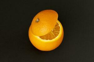 en bonne santé Orange Couper flottant Haut tranche jus boisson idée concept sur noir Contexte photo