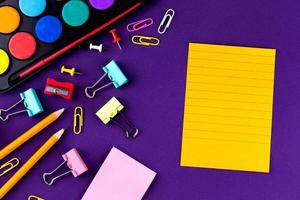 Fournitures de bureau scolaire papeterie sur fond violet photo