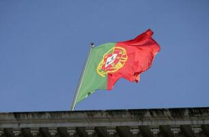 Portugais drapeau agitant dans le vent contre une clair ciel photo