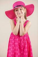 peu fille avec rose robe et chapeau photo