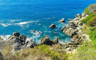 surfeur vagues turquoise bleu l'eau rochers falaises rochers puerto escondido. photo