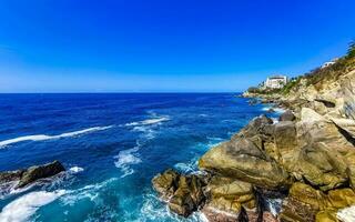 surfeur vagues turquoise bleu l'eau rochers falaises rochers puerto escondido. photo