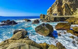 surfeur vagues turquoise bleu l'eau rochers falaises rochers puerto escondido. photo