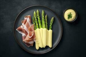 moderne style traditionnel à la vapeur blanc asperges avec guéri jambon et Hollandaise sauce servi comme Haut vue sur une nordique conception assiette avec copie espace, produire ai photo