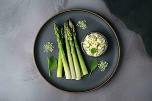 traditionnel bavarois blanc asperges servi avec sauvage Ail et amande beurre fermer sur une nordique conception assiette avec copie espace, produire ai photo