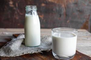 bouteilles et verres à lait sur une table en bois photo