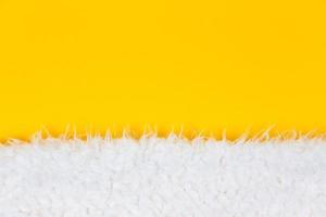 Close-up laine de mouton fourrure duveteux blanc sur fond jaune photo