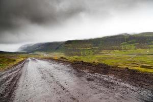 Route de gravier vide dans les régions rurales de l'Islande dans le brouillard photo