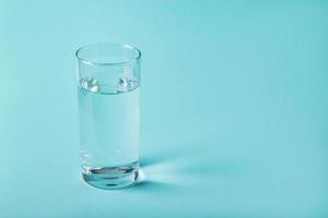 verre d'eau claire sur fond bleu