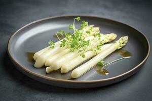 moderne style traditionnel à la vapeur blanc asperges avec guéri jambon et Hollandaise sauce servi comme Haut vue sur une nordique conception assiette avec copie espace, produire ai photo