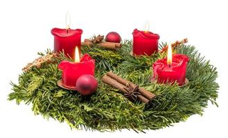 couronne de l'Avent décorée de branches de sapin avec des bougies rouges allumées photo