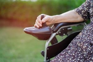 Asiatique senior ou âgée vieille dame patiente sur fauteuil roulant électrique avec télécommande à l'hôpital de soins infirmiers photo