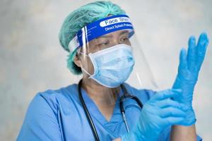 médecin asiatique portant un écran facial et un costume ppe nouvelle norme pour vérifier le patient protéger la sécurité infection épidémie de coronavirus covid 19 dans le service d'hôpital de soins infirmiers de quarantaine photo