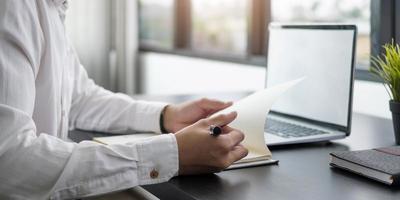 Business planning business man writing on notebook et travaillant sur ordinateur portable dans un bureau moderne homme étudiant cours en ligne via ordinateur portable et conférence sur le bloc-notes photo