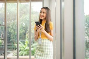 heureux jeune entrepreneur de démarrage de femmes asiatiques heureux et excité souriant après avoir reçu un message pour le succès signe contact d'affaires, fille heureuse sur le lieu de travail. enseignement et travail en ligne à distance. photo