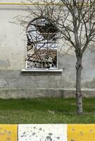 détruit et endommagé fenêtre dans le bâtiment comme une résultat de le guerre. le Maisons étaient détruit et brûlé par artillerie pendant le guerre. cassé les fenêtres. une fenêtre détruit par le lutte. photo