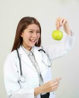 Jeune asiatique femelle médecin portant tablier uniforme tunique tablier tenir photo
