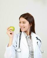 Jeune asiatique femelle médecin portant tablier uniforme tunique tablier tenir photo