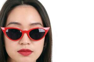 magnifique Jeune Sud est asiatique femme portant rouge Cadre foncé lunettes de soleil pose mode style blanc Contexte studio éclat réflexion photo