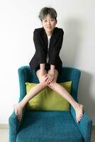 Jeune sud-est asiatique chinois femme séance sur Haut de canapé retour photo
