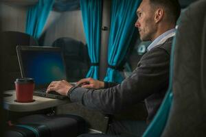homme d'affaire travail sur le sien portable ordinateur pendant entraîneur autobus route voyage photo