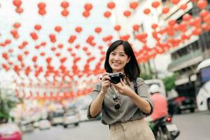 Jeune asiatique femme sac à dos voyageur profiter Chine ville rue nourriture marché dans Bangkok, Thaïlande. voyageur vérification en dehors côté des rues. photo