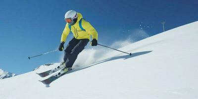 une skieur est Aller vers le bas sur une neigeux Montagne photo