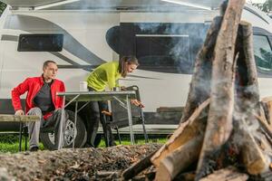 caucasien couple ayant amusement dans de face de feu de camp photo