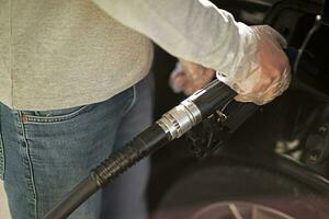 homme à gaz station remplissage en haut voiture avec carburant. photo