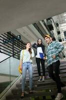 Jeune asiatique malais chinois homme femme intérieur escalier couloir Campus livre fichier dossier portable ordinateur téléphone asseoir supporter étude mêler photo