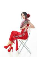 Sud est asiatique chinois course ethnique origine femme portant rouge velours cheongsam avec main cousu séquence travail robe costume main ventilateur sur blanc Contexte photo