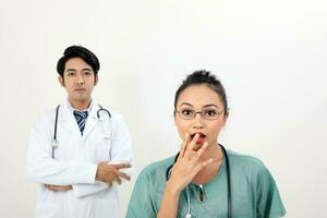 Jeune asiatique malais chinois Masculin femelle médecin sur blanc Contexte surpris sous le choc main sur ouvert bouche à caméra photo
