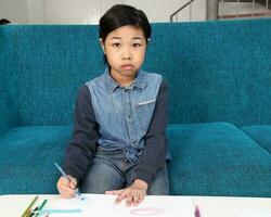 sud-est asiatique petit peu fille enfant en jouant dessin griffonnage stylo papier elle est autistique photo