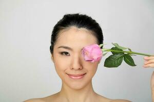 Jeune magnifique sud-est asiatique femme beauté mode maquillage lumière gris blanc Contexte en portant rose Rose plus de œil visage photo